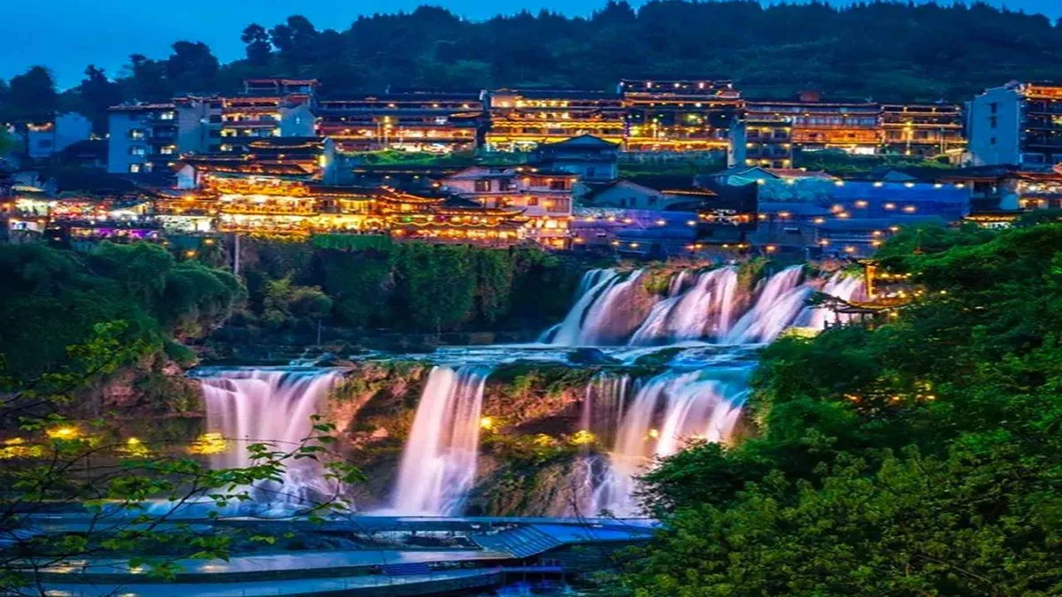 Stilt houses lit at night along the Tuo River in Fenghuang on a Zhangjiajie China tour day trip, Hunan